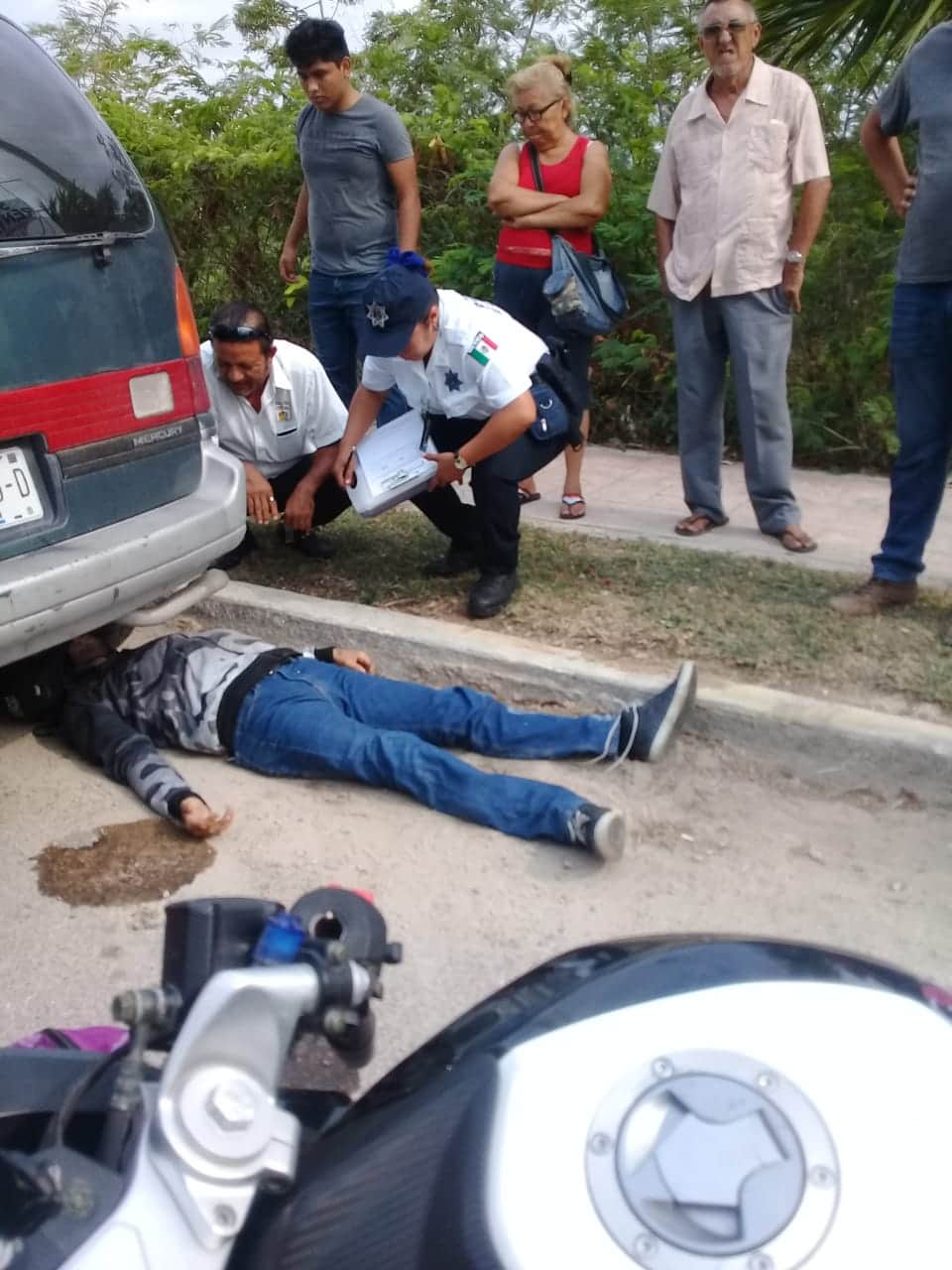 Choca en moto y termina debajo de automóvil