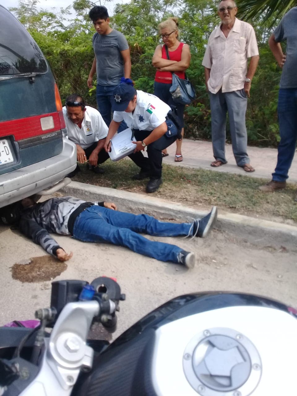 Choca en moto y termina debajo de automóvil