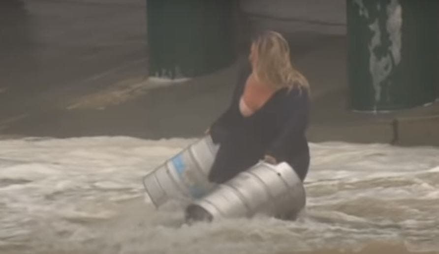 Mujer arriesga su vida con tal de salvar unos barriles de cerveza en una inundación