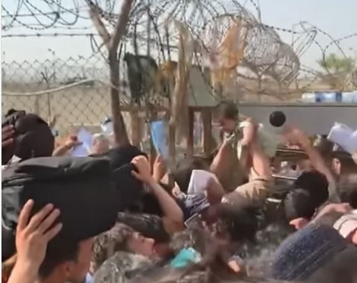 Madre afgana alza a su hijo sobre multitud para que huya en aeronave del Aeropuerto de Kabul