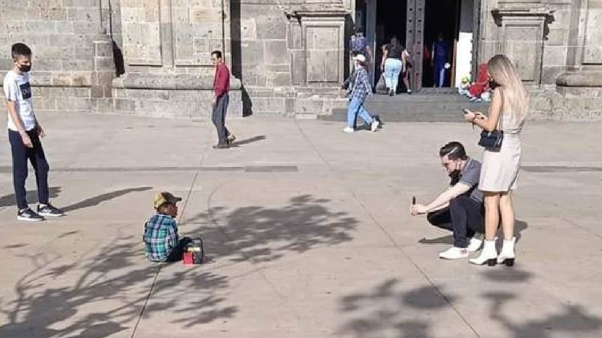 FOTOS: Exhiben en redes a pareja tomando fotos a niño que pedía limosna