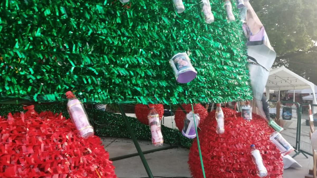 Colectivo coloca “esferas” con fotos de sus hijos desaparecidos en árbol de Navidad en el centro de Cancún